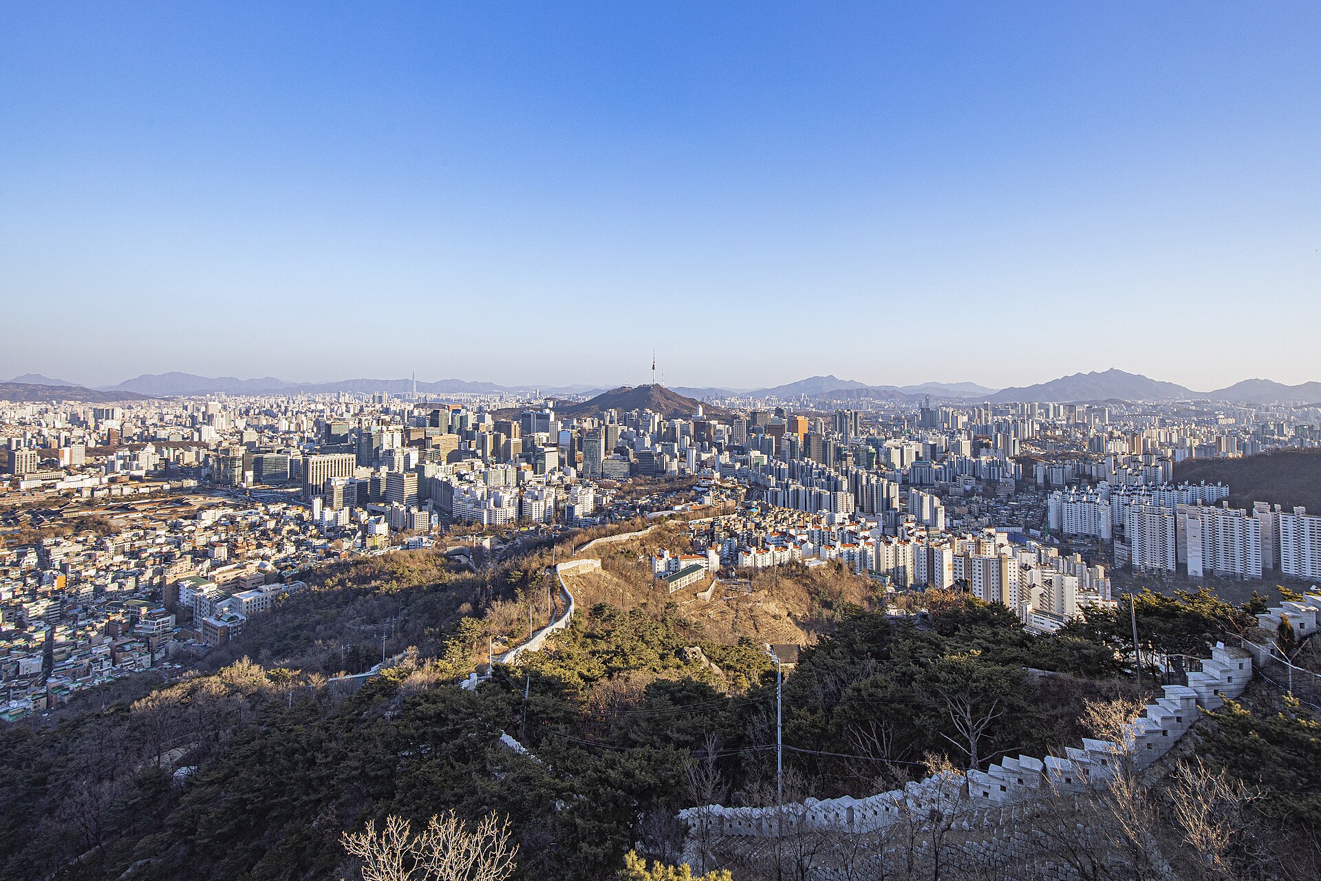 Vista panorámica de la Muralla de Seúl en el monte Inwangsan con el centro moderno de la ciudad al fondo.