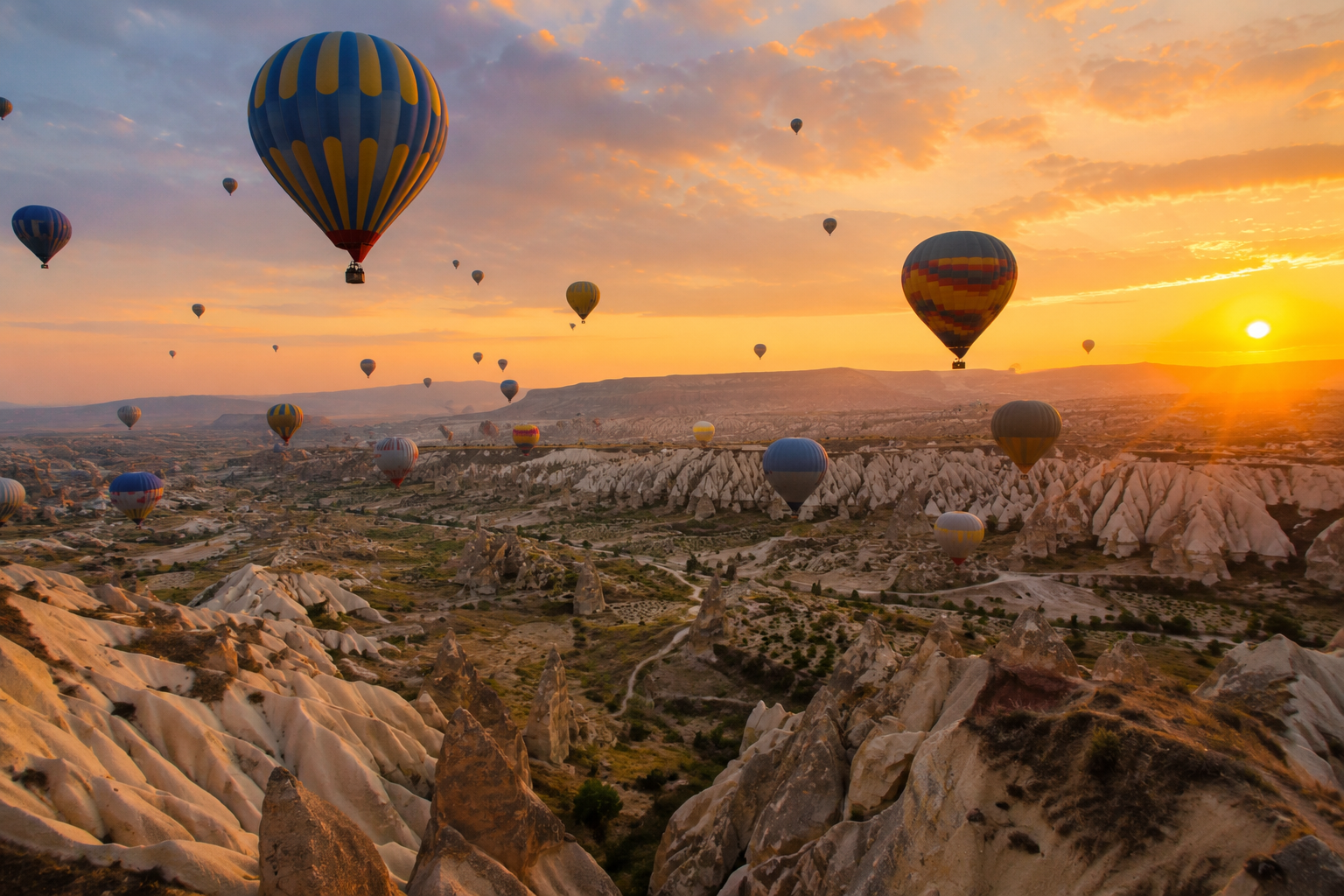 Hot air balloons floating at golden hour over dramatic rock formations