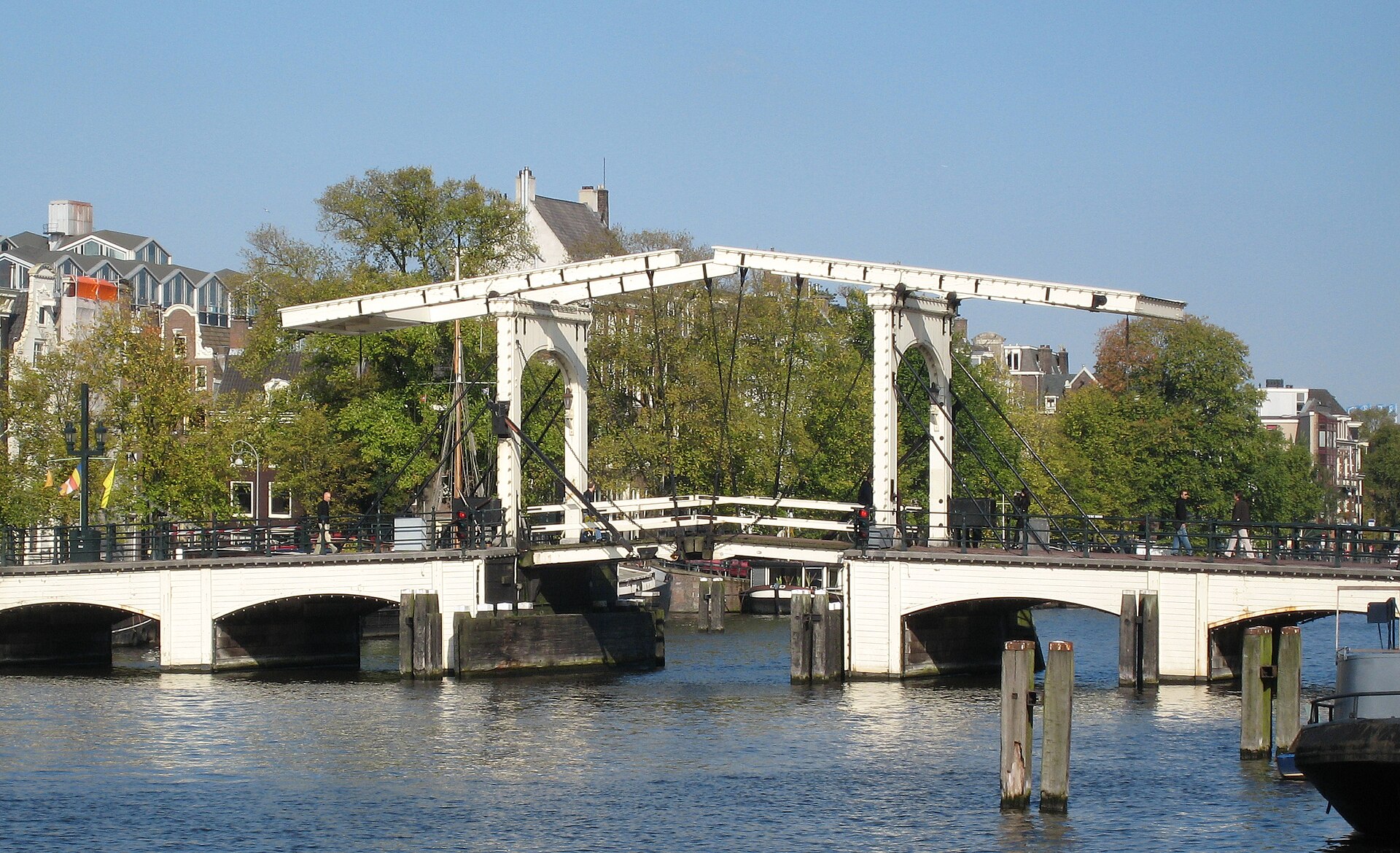 Puente Magere Brug iluminado sobre el río Amstel en Ámsterdam