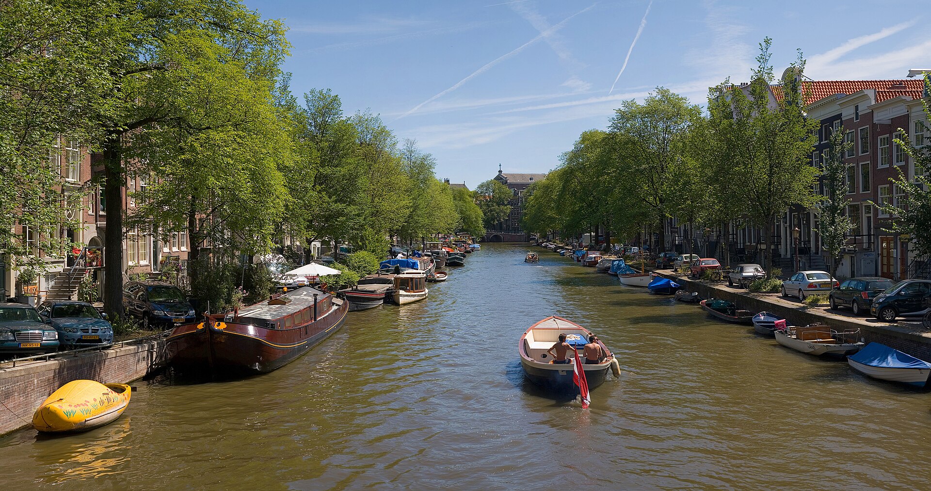Panorámica de los canales históricos de Ámsterdam con casas de ladrillo y puentes al atardecer
