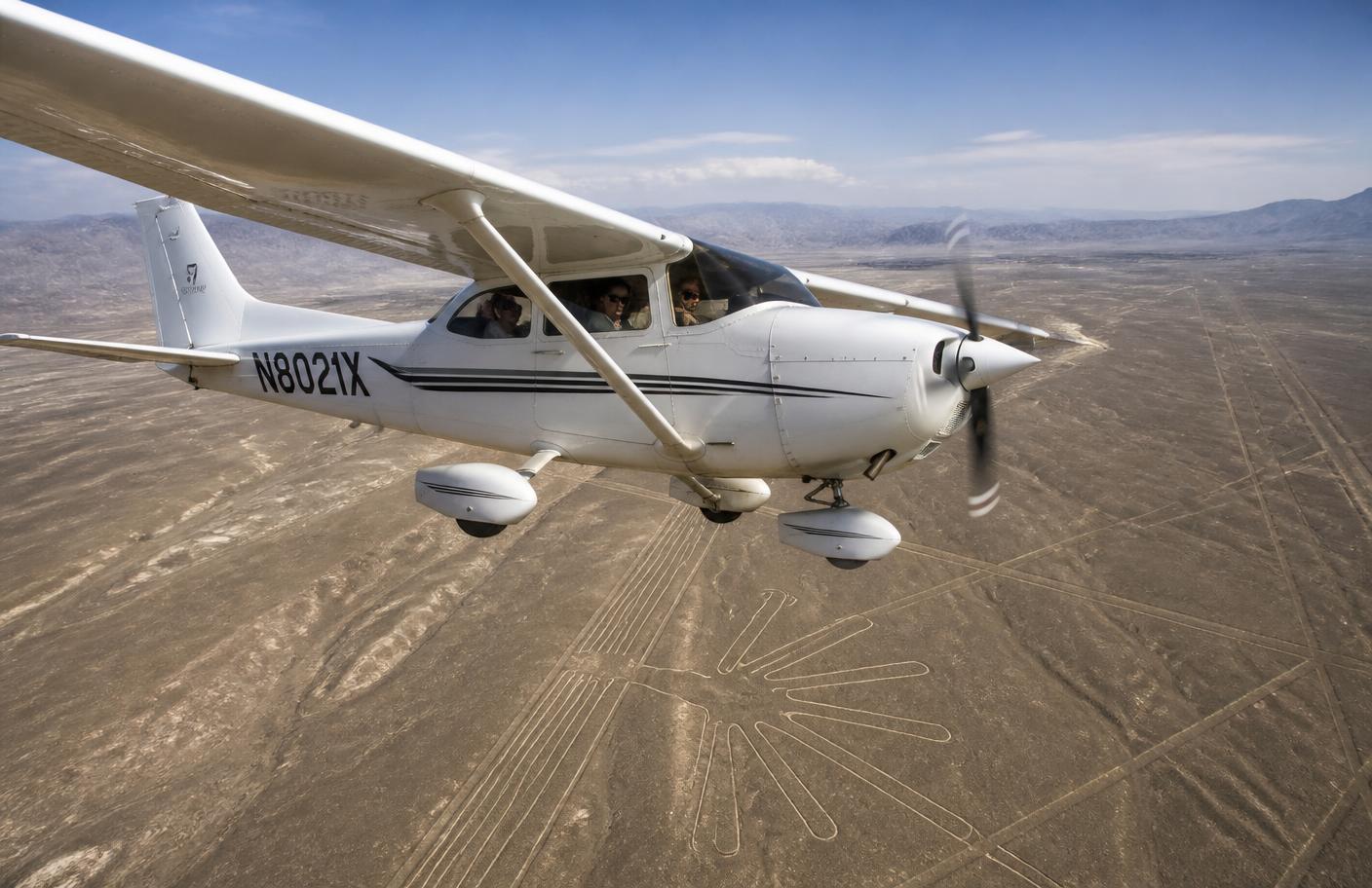 Avioneta pequeña volando sobre el desierto de Nazca