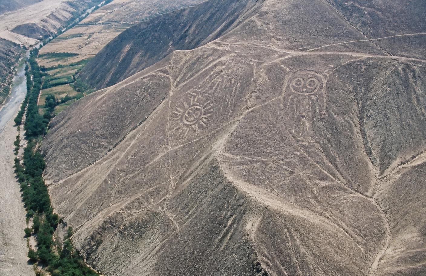 Geoglifos trazados en laderas desérticas sobre un valle verde cerca de Palpa