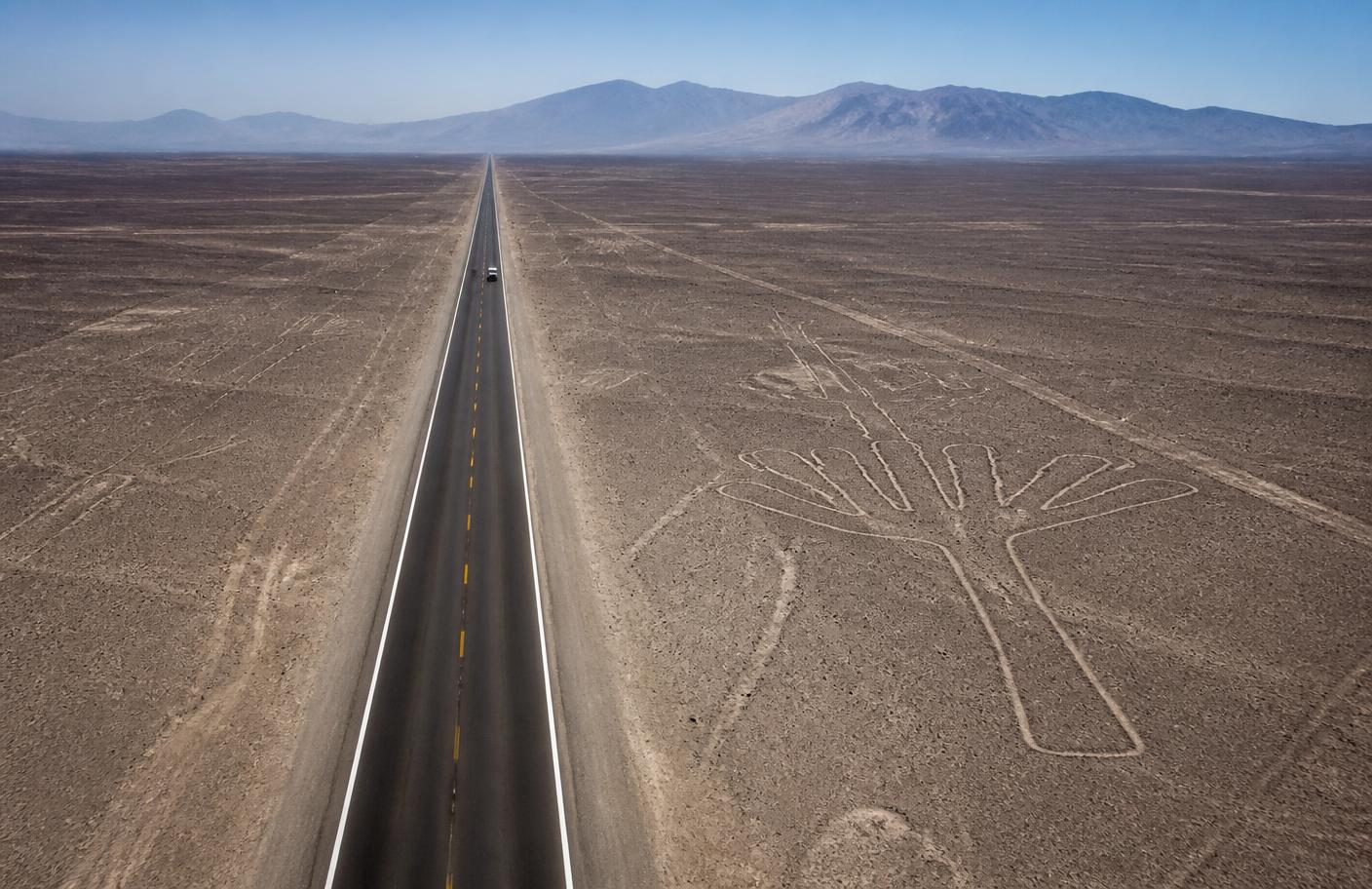 Carretera atravesando el desierto de Nazca junto a un geoglifo